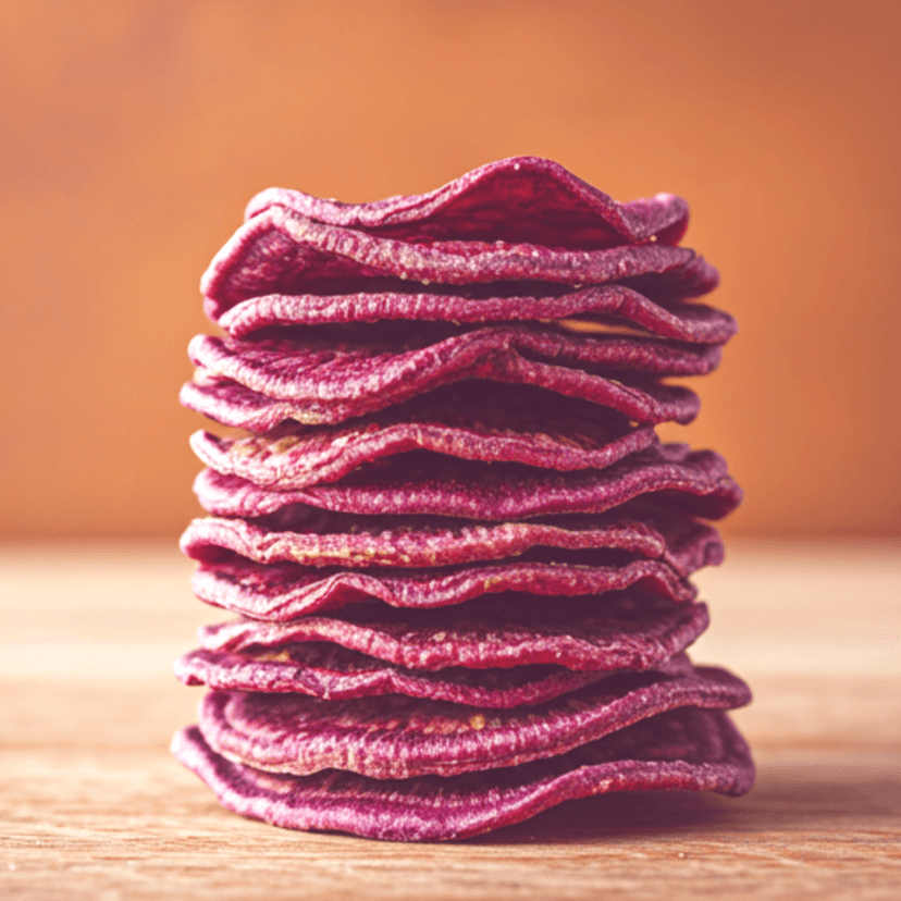 Vibrant pink dragon fruit chips showing delicate texture and speckled seeds